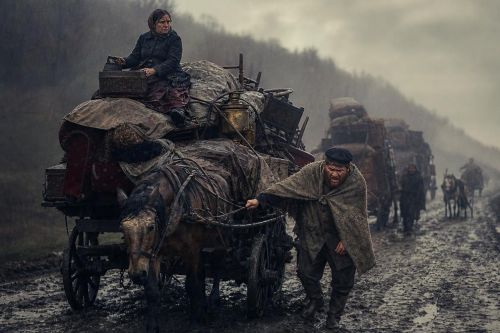 Перегруженная телега дачников вязнет в грязном шоссе